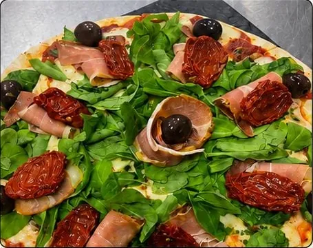 Pizza de rúcula con jamón crudo y tomates secos